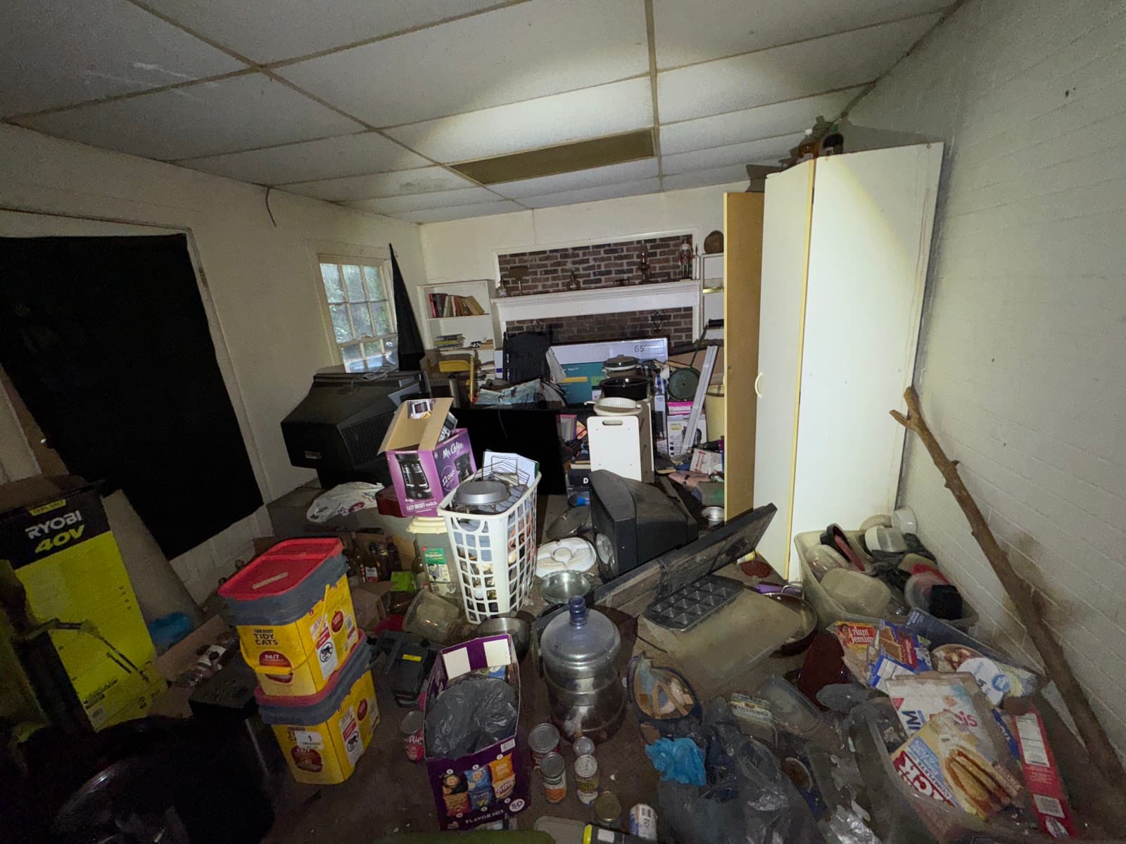 Squatter aftermath interior of an NC rental property bought as-is by Atlantis Homebuyers, belongings stacked and property non-habitable